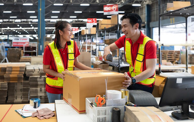 Warehouse staff packing goods for shipping order dispatch. Asian woman and colleague working in...