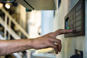close up engineer hand finger press button controling cnc machine, Workers operating factory machinery in warehouse