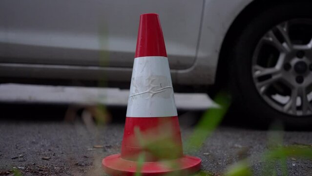 Close-up road cone with car passing at background. Concept of driving lessons