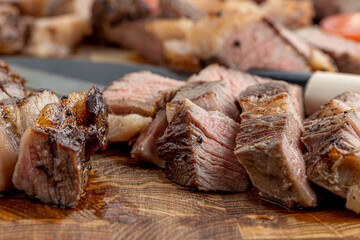 A steak on a cutting board with herbs and spices.Grilled beef tenderloin steak on a wooden board with grilled vegetables. Filet Mignon recipe concept, selective focus