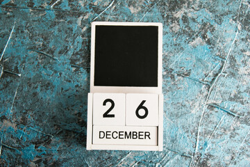 Wooden calendar on a dark background. December 26 is the day of gifts.