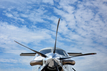 The nose of a Pilatus as seen from the front looking up.  Blue sky and cirrus clouds in the...