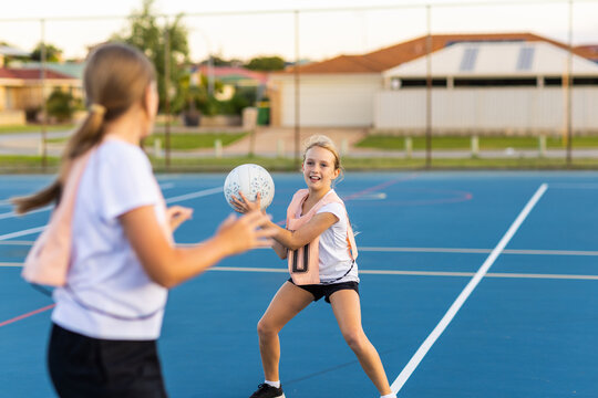two children playing netball on outside netball court