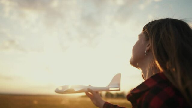 little girl running in the park with a toy airplane. happy family kid dream future concept. child girl silhouette plays with a toy airplane lifestyle runs on the grass in the summer in the park