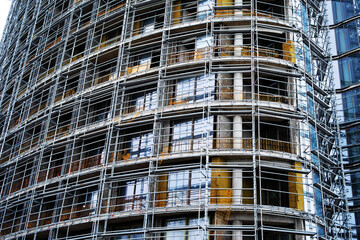 Construction of multi-apartment high-rise buildings. Multi-storey building and scaffolding