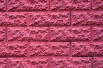 Pink decorative brick effect tiles on the facade of the house. Abstract brick wall background