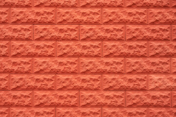 Orange decorative tiles under the brick on the facade of the house. Abstract brick wall background