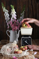 still life with peaches on vintage scales and in string bag,bouquet of foxgloves