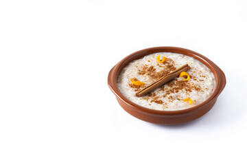 Arroz con leche. Rice pudding with cinnamon in clay bowl isolated on white background. Copy space