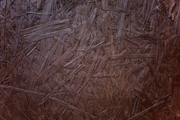 The surface of a dark brown board made of pressed sawdust. Finishing materials in construction, design and repair. Background. Space for text.