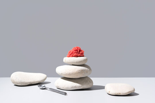 Caviar de trucha sobre piedras blancas. Comida gourmet sobre fondo gris	