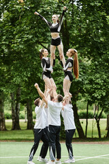 Vertical image of cheerleader team performing together outdoors, they dancing and doing tricks