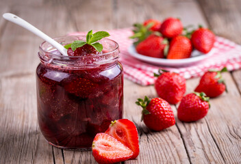 Homemade delicious strawberry jam and strawberry on a rustic wooden table - obrazy, fototapety, plakaty