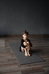 Fototapeta na wymiar Small child girl 4 5 years old doing gymnastics training in the studio class, healthy active education. Yoga, dancing or gymnastics for kids