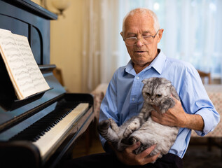 Photo of old pianist with cat
