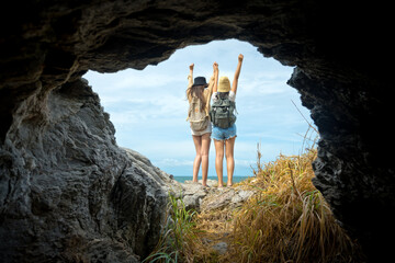 View from natural tunnel cave of the sea island of traveler hiking step to the destination of the trip, cheerfully at the arrival destination