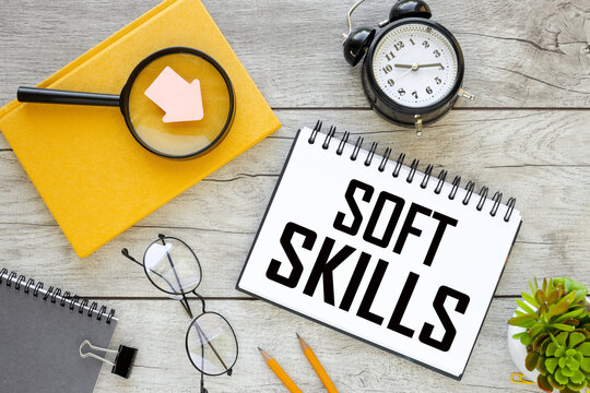 sticker points to text. bright yellow notebook. a table clock. Soft skills