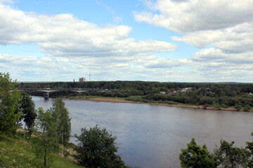 Beautiful view of a flowing river in summer with trees and fields.