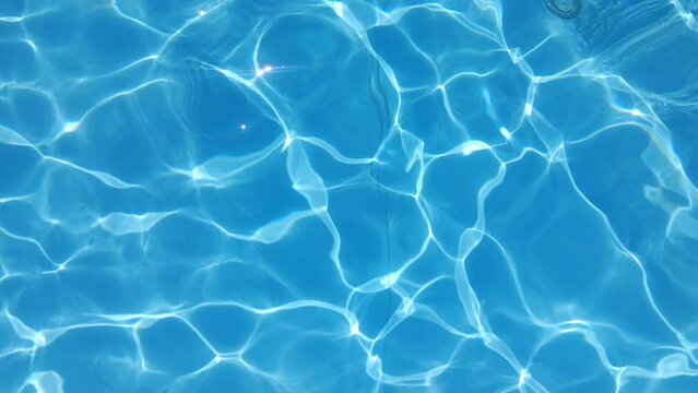 Blue water in the pool with sun glare.