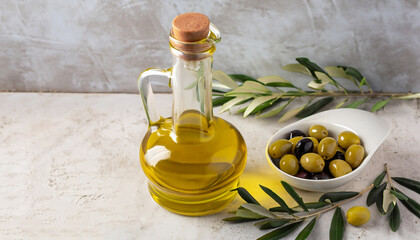 Olive oil in a glass bowl and gravy boat on a textured background. Oil bottle with branches and...