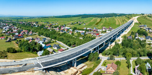 New fragment of highway under construction on Zakopianka road in Poland from Krakow to Zakopane over Klikuszowa village, main place of traffic jams near Nowy Targ. State in July 2023. Aerial panorama - 625180949