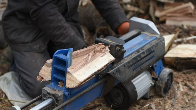 Hydraulic wood splitter splits wormwood. Preparation for the winter.