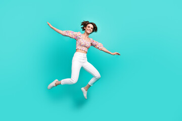 Fototapeta na wymiar Full body photo of overjoyed cheerful lady jumping raise hands flying empty space isolated on teal color background