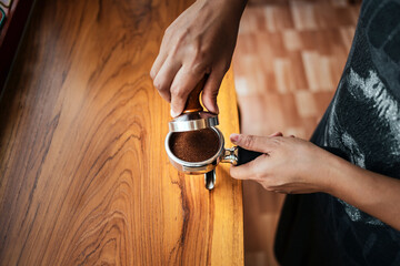  Hand Barista cafe making coffee with manual presses ground coffee using tamper at the coffee shop