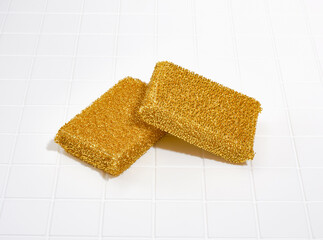 Two abrasive cleaning sponges for washing dishes lie in the white table. Cleanliness.