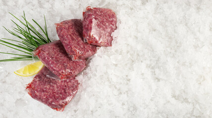 Beef Meat Patties in Vacuum Bags on Ice on white Background - Panorama