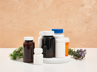 Many medical jars with tablets of brown and white color on a white round stand. Health care.