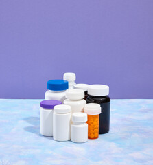 A set of medical jars in orange, white and brown color with various useful pills for treating illnesses. Drug therapy. Copy space for text.