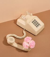 Phone with the handset off on the table. Vintage and old phone with flowers.