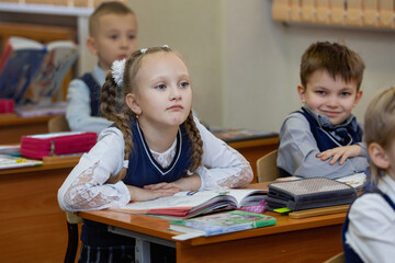 Schoolgirl at the desk in classroom in school