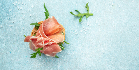 Toast with jamon serrano ham, prosciutto crudo parma. Long banner format. top view