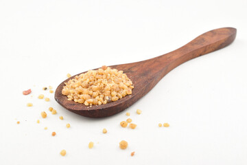 Asafoetida in wooden spoon on white background