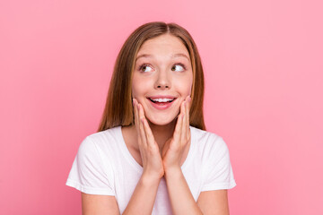 Portrait of charming cheerful minded girl hands touch cheeks look empty space ad isolated on pink color background