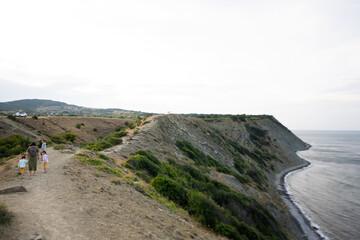 Family walking against beautiful seascape on the Black Sea coast in Bulgaria.