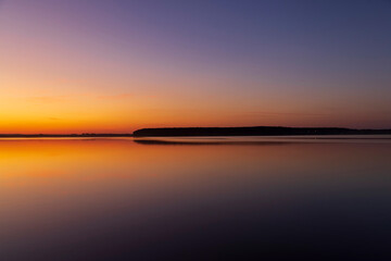 beautiful orange-yellow sunset on the lake in spring