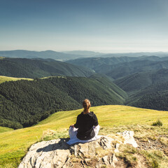 Young woman on the top of mountain