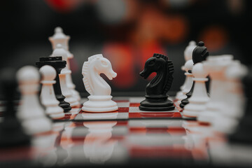 chess knight figure in competition success play. strategy, management, or leadership concept. knight challenge center. Pieces on the chessboard. falling pieces on chessboard  © sumblistan
