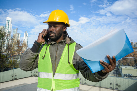 young black man builder talking on the phone discussing angry with an employee