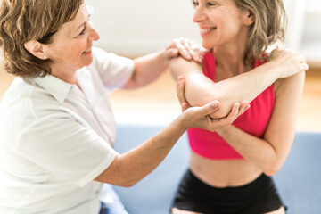 elderly Physiotherapist working with sporty patient in clinic