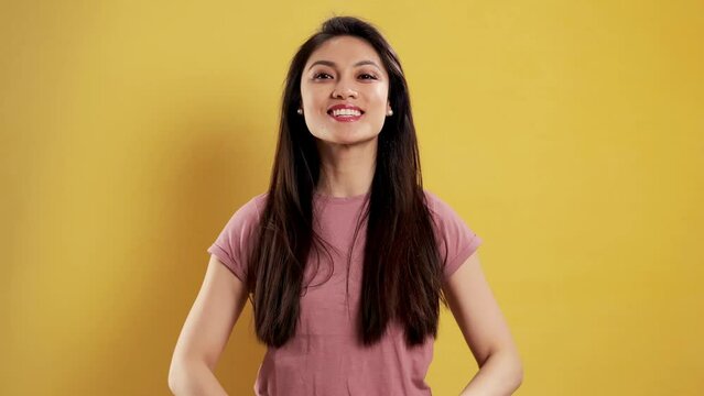 Asian Girl with a confident smile in a studio posing for the camera - extreme slow motion shot