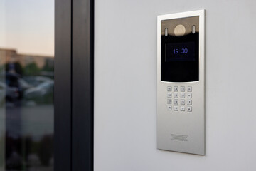 Doorbell with video camera and microphone, on the white wall of an apartment building, doorbell...