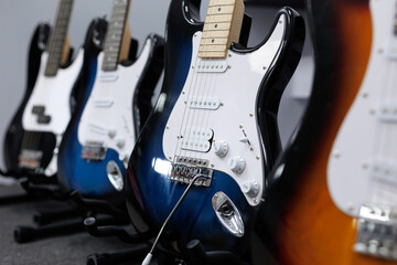 An assortment of multi-colored electric guitars is on display in the music store