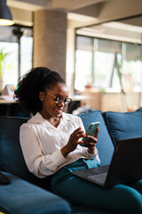 Black businesswoman working on laptop. Portrait of beautiful businesswoman using the phone in the office.