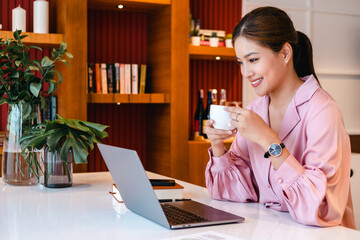 Morning coffee break during work from home. Woman working on computer in office. ..Video conference remote call. Business internet telework. Businesswoman drinking coffee by laptop.