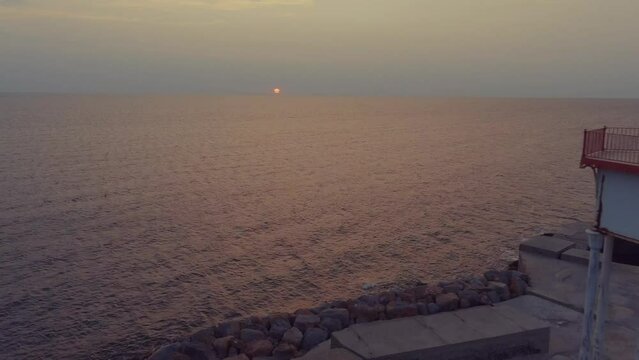 Phare du m&ocirc;le clignotant au soleil levant