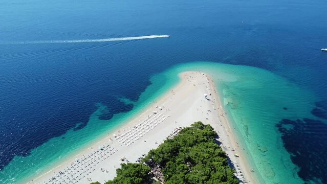 Aerial view of Zlatni Rat (Golden Horn or Golden Cape), beach on Brac Island in Croatia, with people swimming. Tourists enjoying summer travel in Europe. Crystal clear blue waters of Adriatic Sea